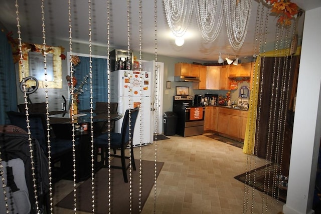 kitchen with dark countertops, stainless steel range with electric stovetop, freestanding refrigerator, an inviting chandelier, and under cabinet range hood