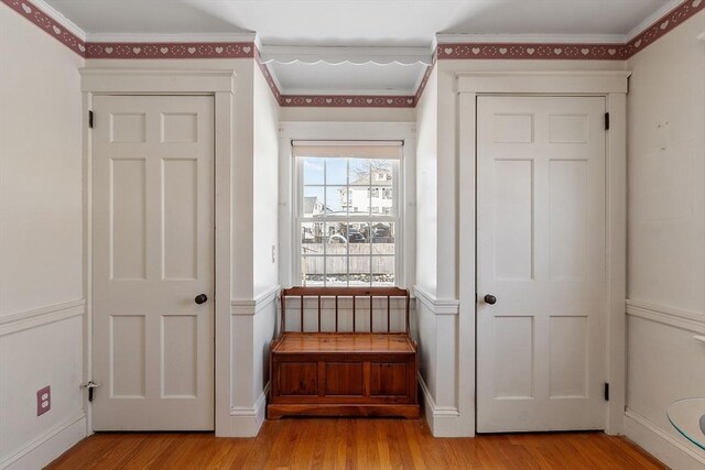 interior space featuring light wood-style flooring, ornamental molding, and baseboards