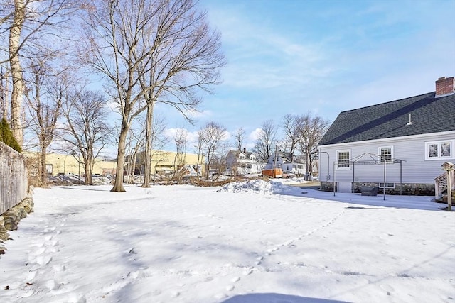 yard covered in snow featuring fence