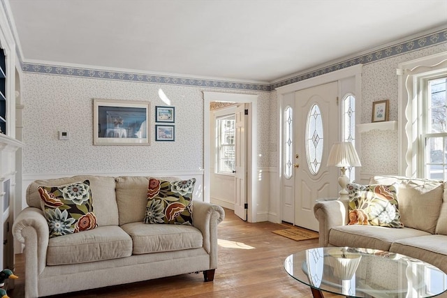 living room with a healthy amount of sunlight, wainscoting, light wood-style flooring, and wallpapered walls