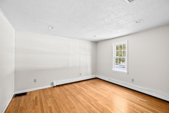 unfurnished room with a baseboard radiator, wood-type flooring, and a textured ceiling