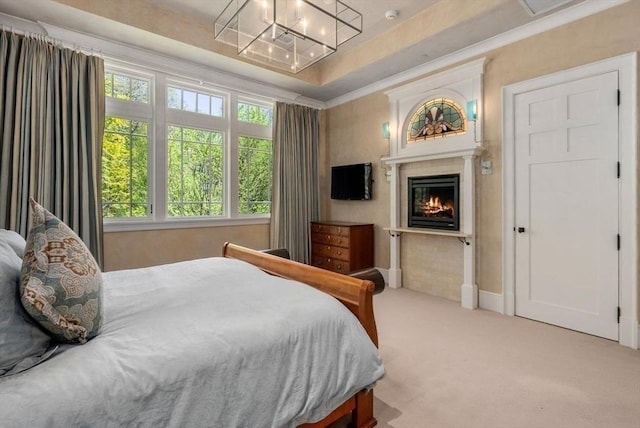 carpeted bedroom with crown molding and a tray ceiling