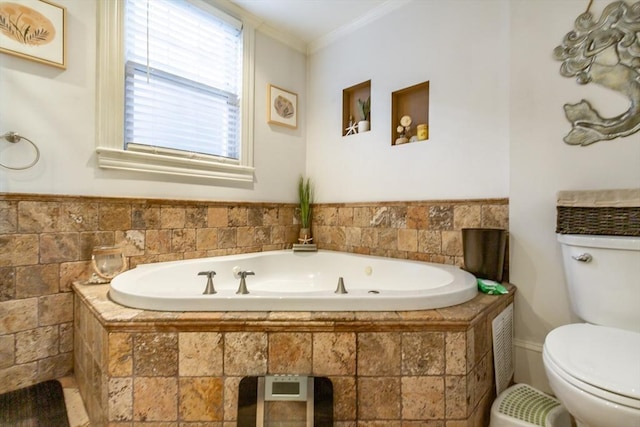 bathroom featuring a relaxing tiled tub, crown molding, and toilet