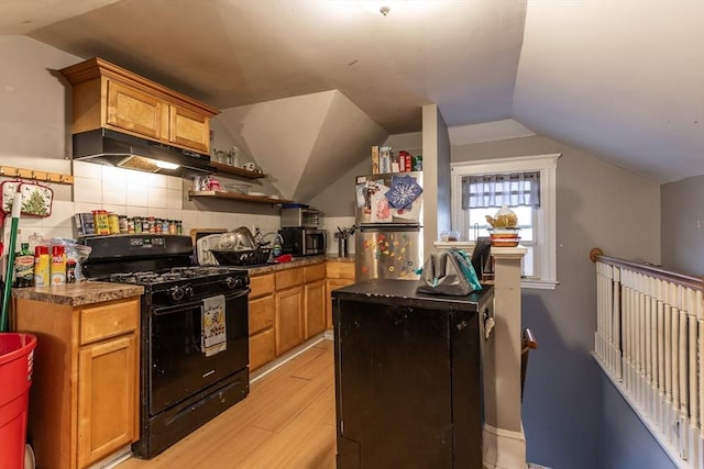 kitchen featuring lofted ceiling, decorative backsplash, stainless steel appliances, and light wood-type flooring