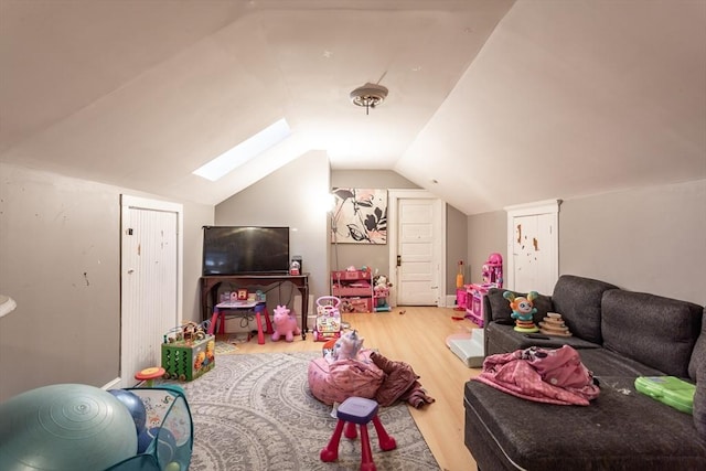 playroom featuring hardwood / wood-style flooring and lofted ceiling with skylight