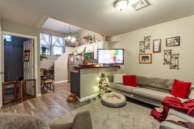 living room with wood-type flooring and a chandelier