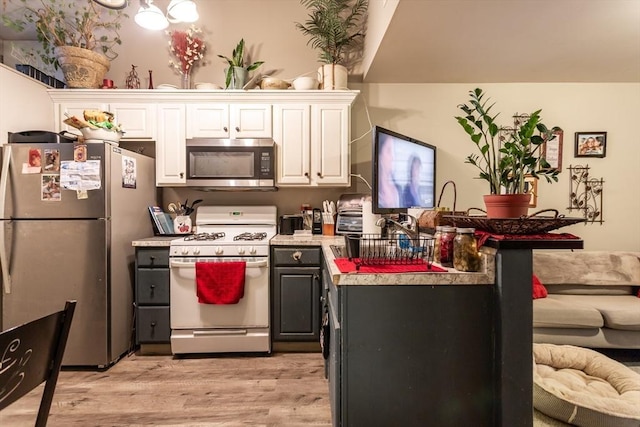 kitchen with stainless steel appliances, light wood-type flooring, and white cabinets