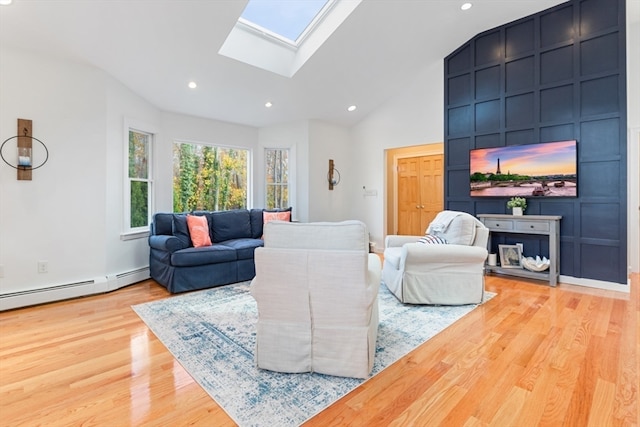 living room with a baseboard heating unit, light wood-type flooring, high vaulted ceiling, and a skylight