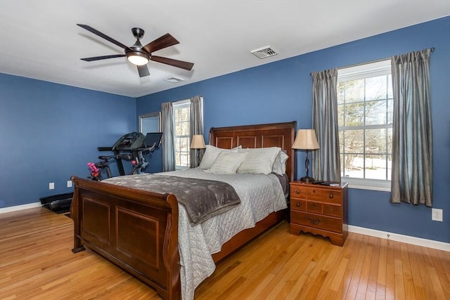 bedroom featuring baseboards, multiple windows, visible vents, and light wood-style floors