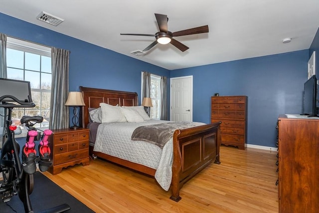 bedroom with light wood-type flooring, visible vents, and baseboards