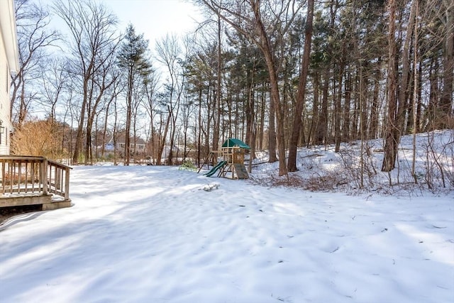 yard covered in snow featuring a playground