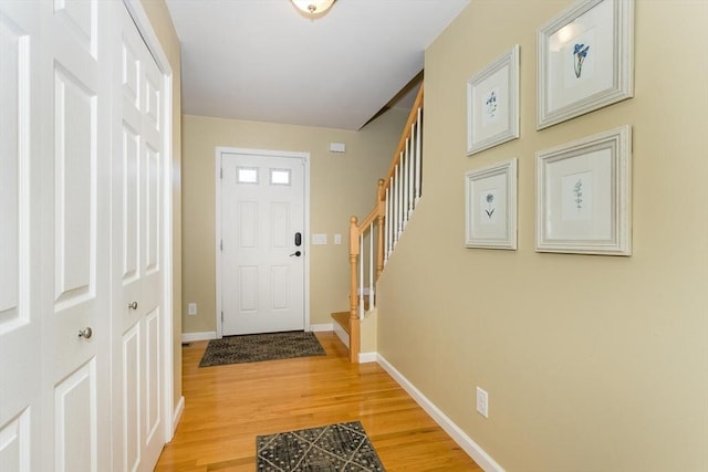 doorway to outside featuring stairs, baseboards, and wood finished floors