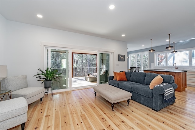 living room with light hardwood / wood-style flooring and sink