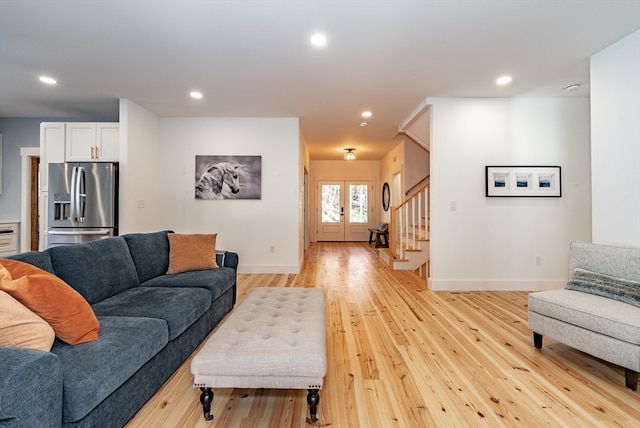 living room featuring french doors and light hardwood / wood-style flooring