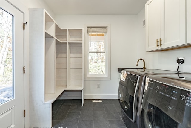 washroom featuring washer and clothes dryer and cabinets