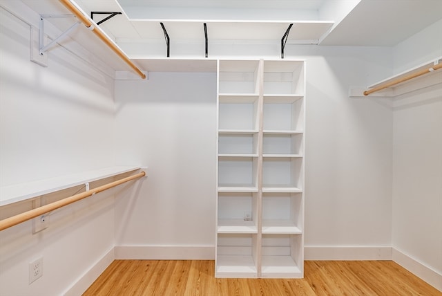 walk in closet with hardwood / wood-style flooring