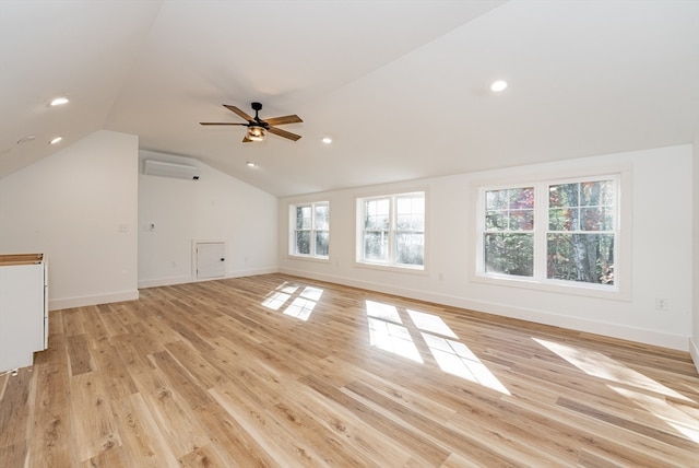 additional living space with light wood-type flooring, an AC wall unit, ceiling fan, and lofted ceiling