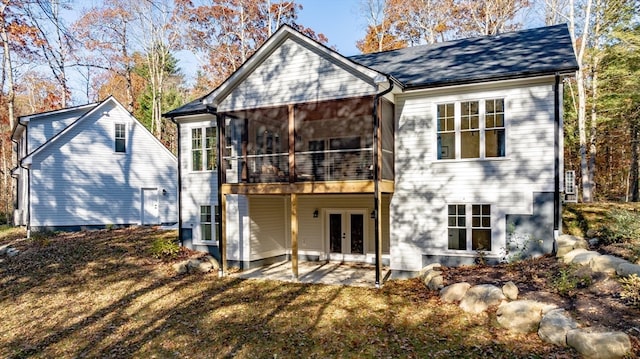 rear view of property featuring a sunroom, a patio, and french doors