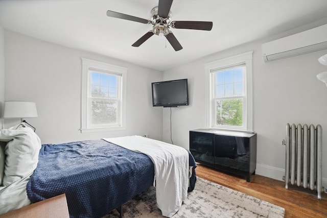 5 Ellington Rd, Quincy, MA 02171 - bedroom featuring radiator heating unit, wood finished floors, a wall mounted AC, and multiple windows