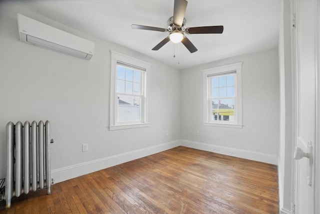 5 Ellington Rd, Quincy, MA 02171 - empty room with radiator, a wall mounted air conditioner, healthy amount of natural light, and hardwood / wood-style flooring