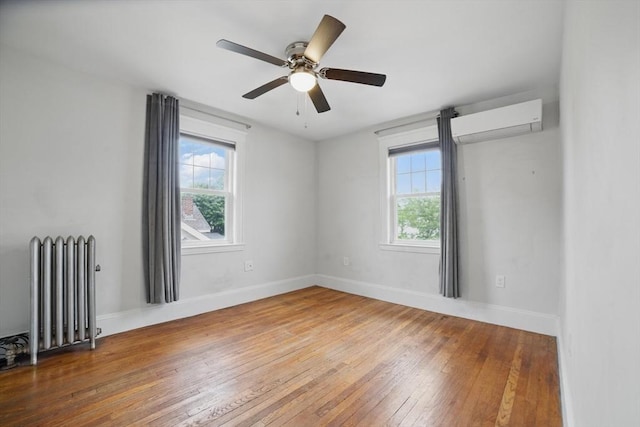 5 Ellington Rd, Quincy, MA 02171 - spare room featuring radiator, an AC wall unit, hardwood / wood-style floors, and healthy amount of natural light
