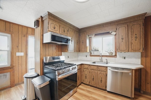5 Ellington Rd, Quincy, MA 02171 - kitchen with appliances with stainless steel finishes, a sink, brown cabinets, light countertops, and wooden walls