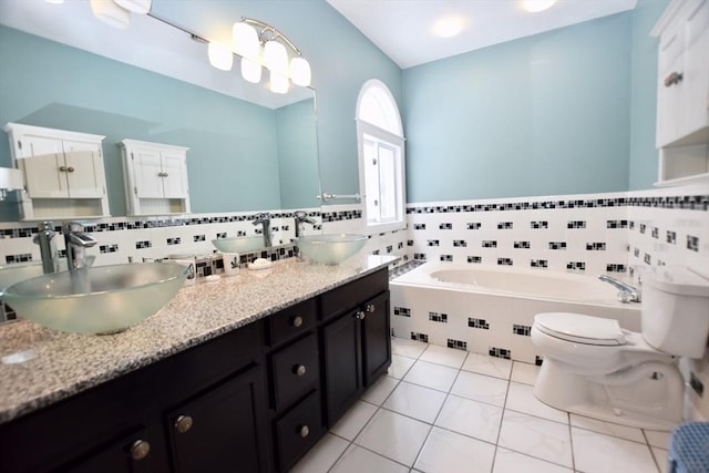 full bathroom featuring toilet, double vanity, a sink, and a bath