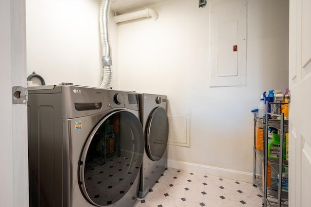 laundry room with light floors, washing machine and dryer, laundry area, electric panel, and baseboards