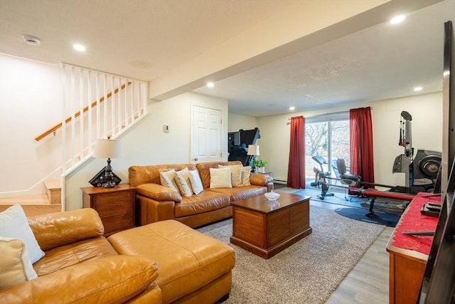 living area with a baseboard heating unit, light wood-style flooring, stairway, and recessed lighting