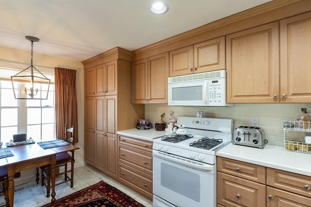 kitchen with light tile patterned floors, white appliances, an inviting chandelier, and pendant lighting