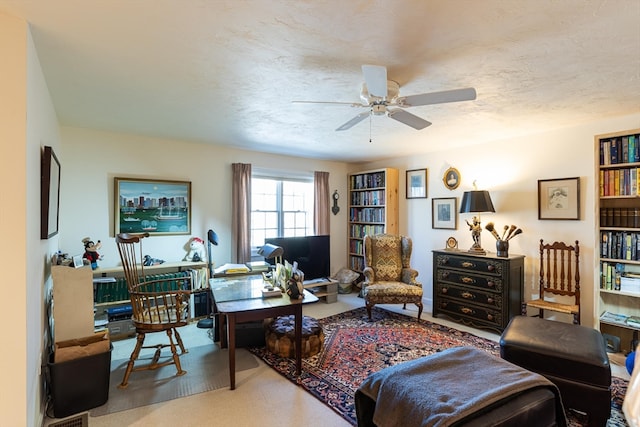 living room with ceiling fan and a textured ceiling