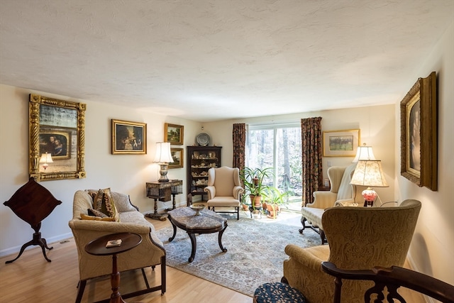 living room with light hardwood / wood-style floors and a textured ceiling