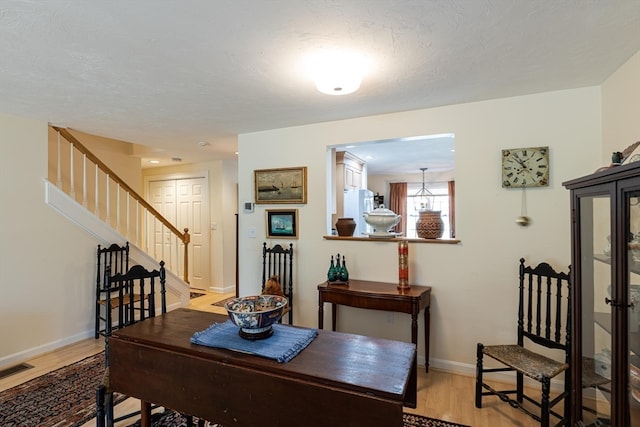 dining room with a textured ceiling and light wood-type flooring