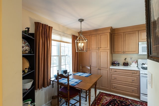 kitchen featuring light tile patterned floors, white appliances, a chandelier, and decorative light fixtures