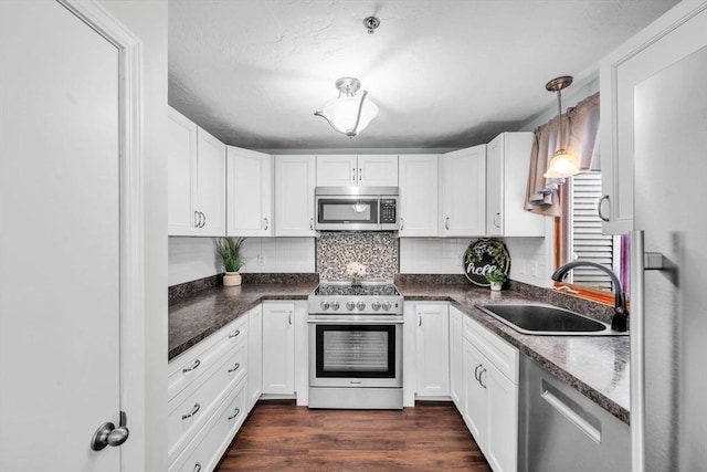 kitchen featuring pendant lighting, appliances with stainless steel finishes, sink, and white cabinets