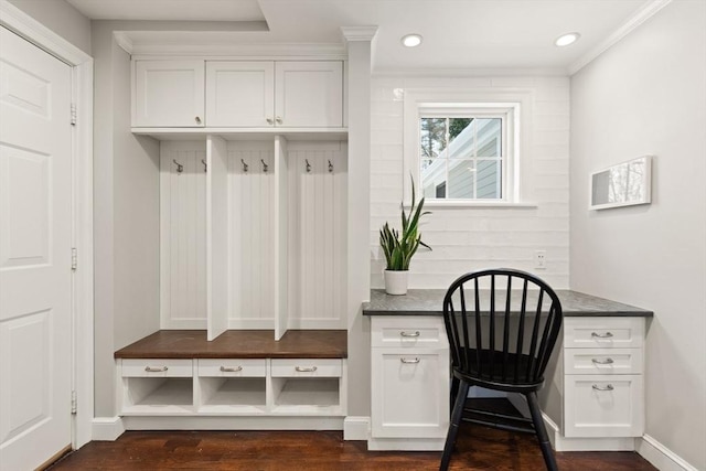 mudroom featuring crown molding, dark hardwood / wood-style floors, and built in desk