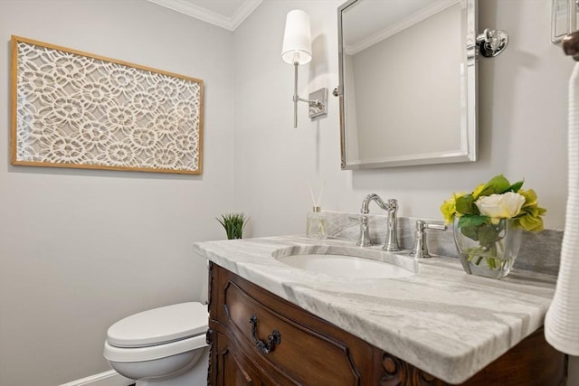 bathroom with ornamental molding, toilet, and vanity