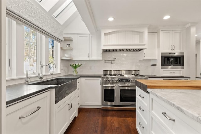 kitchen featuring sink, white cabinetry, appliances with stainless steel finishes, dark hardwood / wood-style floors, and decorative backsplash