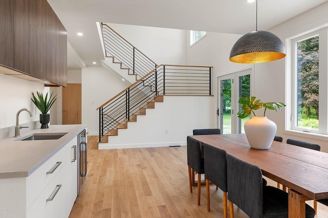 dining area with stairs, light wood finished floors, a wealth of natural light, and recessed lighting