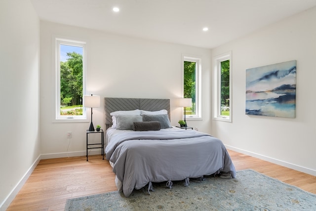 bedroom with multiple windows and hardwood / wood-style floors