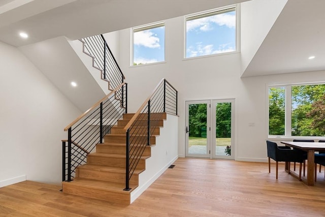 foyer entrance featuring recessed lighting, stairway, a high ceiling, light wood-type flooring, and baseboards