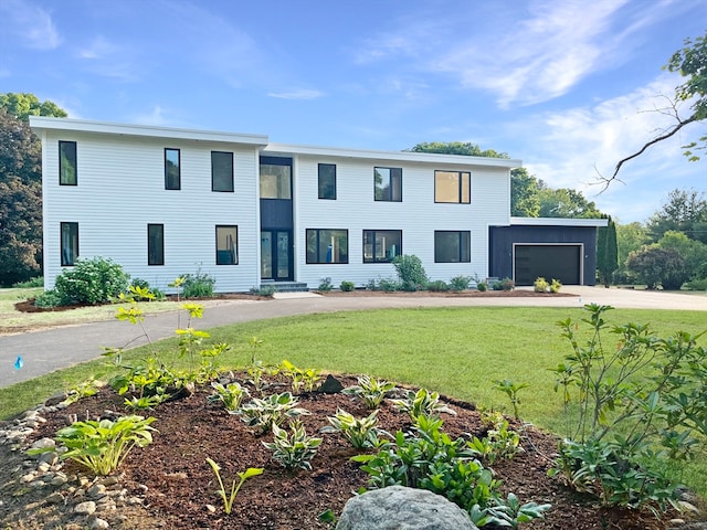 view of front of property featuring a garage and a front lawn