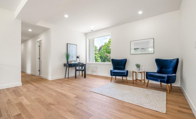 living area with light wood-type flooring, baseboards, and recessed lighting