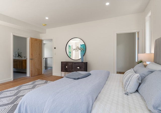 bedroom featuring ensuite bathroom and hardwood / wood-style flooring