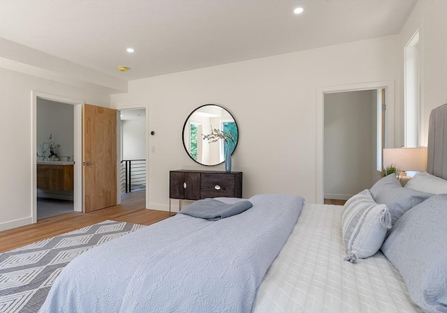 bedroom with baseboards, wood finished floors, and recessed lighting