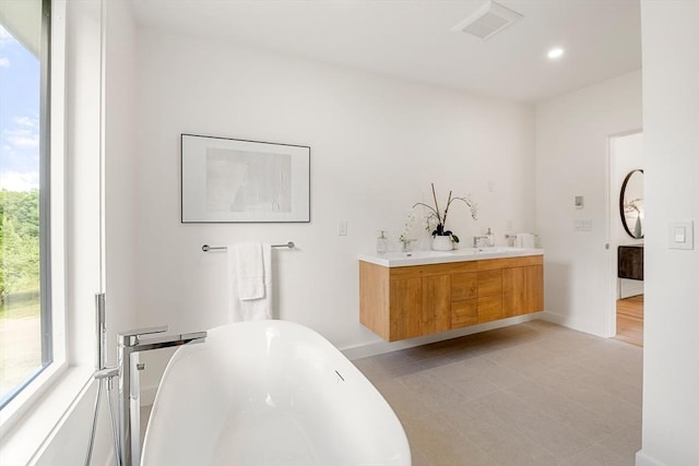 full bath featuring a healthy amount of sunlight, visible vents, and a freestanding bath