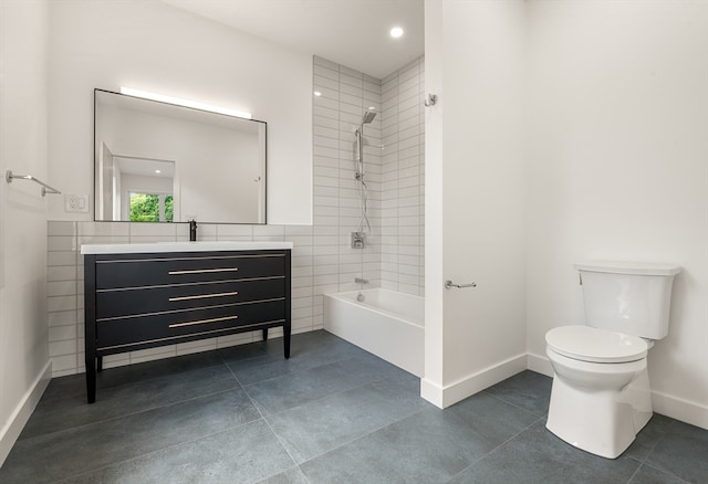 full bathroom with tile walls, toilet, tiled shower / bath combo, tile flooring, and vanity