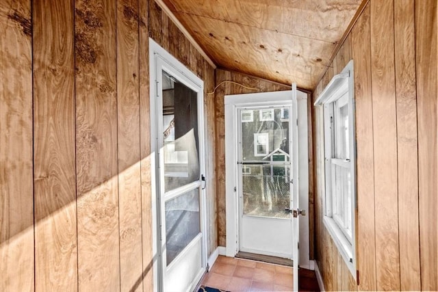 entryway with lofted ceiling, wooden walls, and wooden ceiling