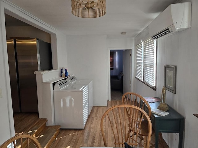 68 Lake Shore Dr, West Brookfield, MA 01585 - kitchen featuring separate washer and dryer, a wall unit AC, wood finished floors, and freestanding refrigerator