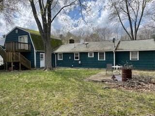 rear view of property featuring a yard and stairway
